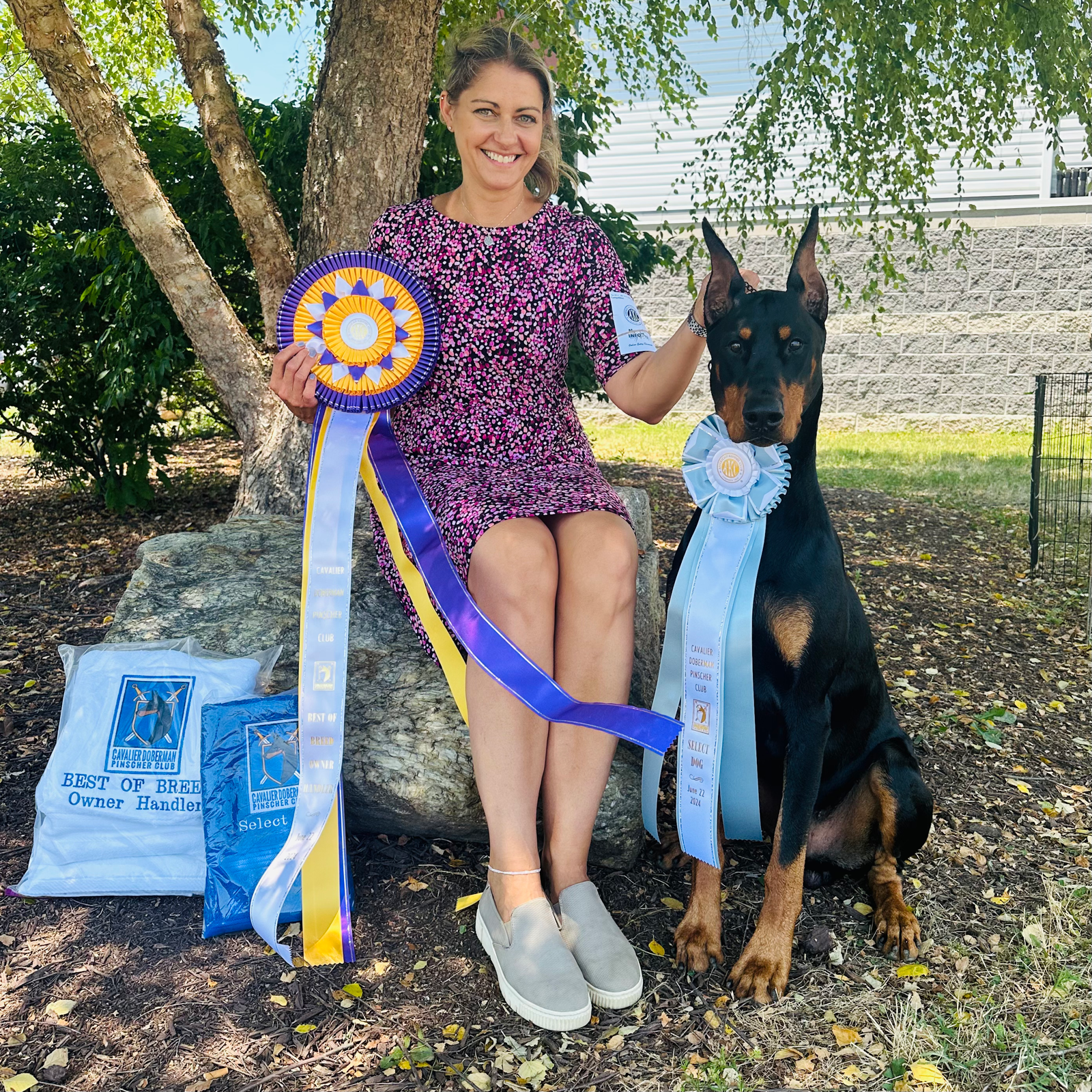 Kimberly Gabor Piorkowski at a dog show with her Doberman and award ribbons